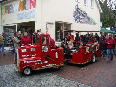 Bimmelbahn Seitenansicht mit Fahrgästen auf dem Letztmarkt in Wittmund